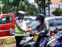 Sambut HUT RI ke-78 Polrestabes Surabaya Berbagi Bendera Merah Putih ke Pengguna Jalan