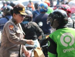 Sapa Warga di Hari Jadi ke -76, Polwan Polrestabes Surabaya Turun Jalan Berbagi Helm dan Bunga