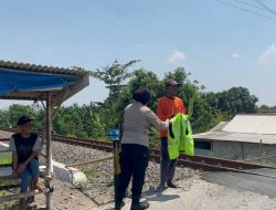 Personel Sat Binmas Polres Kediri memberikan rompi keselamatan kepada relawan penjaga palang pintu perlintasan kereta api