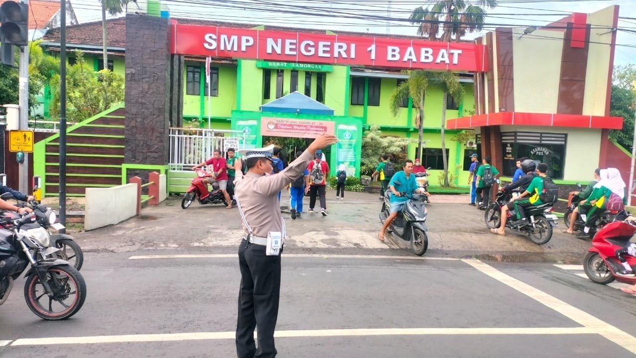 Anggota Polsek Babat Laksanakan Pengaturan Lalu Lintas Di Wilayah Kecamatan Babat Saat Jam Sekolah
