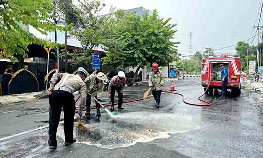 Sigap, polisi bersama damkar bersihkan tumpahan solar di jalan raya lamongan antisipasi kecelakaan