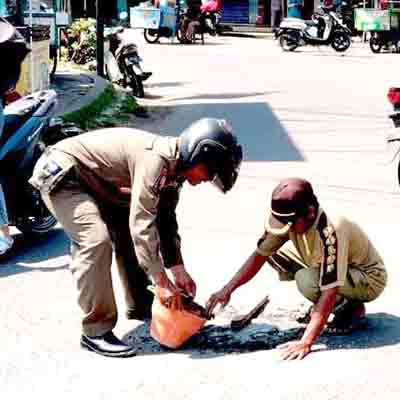 Satpol pp kedungpring tutup lubang jalan di depan pasar, warga diminta waspada