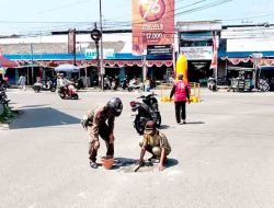 Satpol PP Kedungpring Tutup Lubang Jalan di Depan Pasar, Warga Diminta Waspada